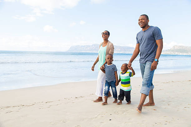 istock African family walking on the beach 499169511