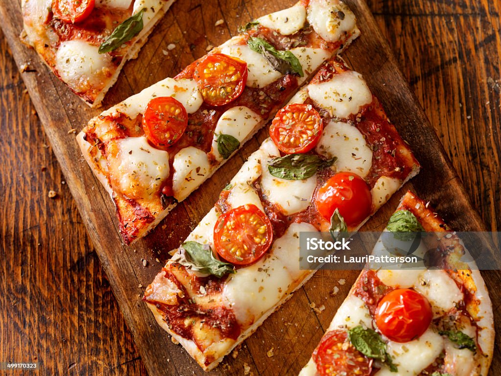 Margherita Flat Bread Pizza Margherita Pizza with Fresh Mozzarella,Tomatoes and Basil on Thin Flat Bread - Photographed on a Hasselblad H3D11-39 megapixel Camera System Pizza Stock Photo