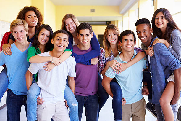 gruppo di studenti delle scuole superiori offrendo piggybacks nel corridoio - high school age foto e immagini stock