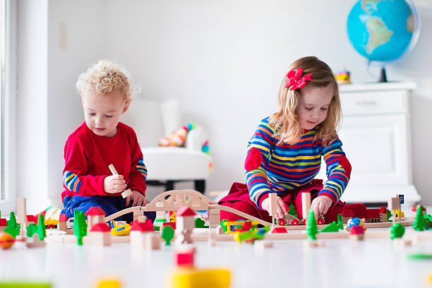 istock Cute children playing with toy railroad and train 499171080