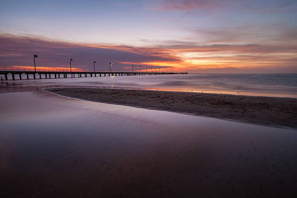 istock Smooth water surface and pier in orange sunset  colors 499171903