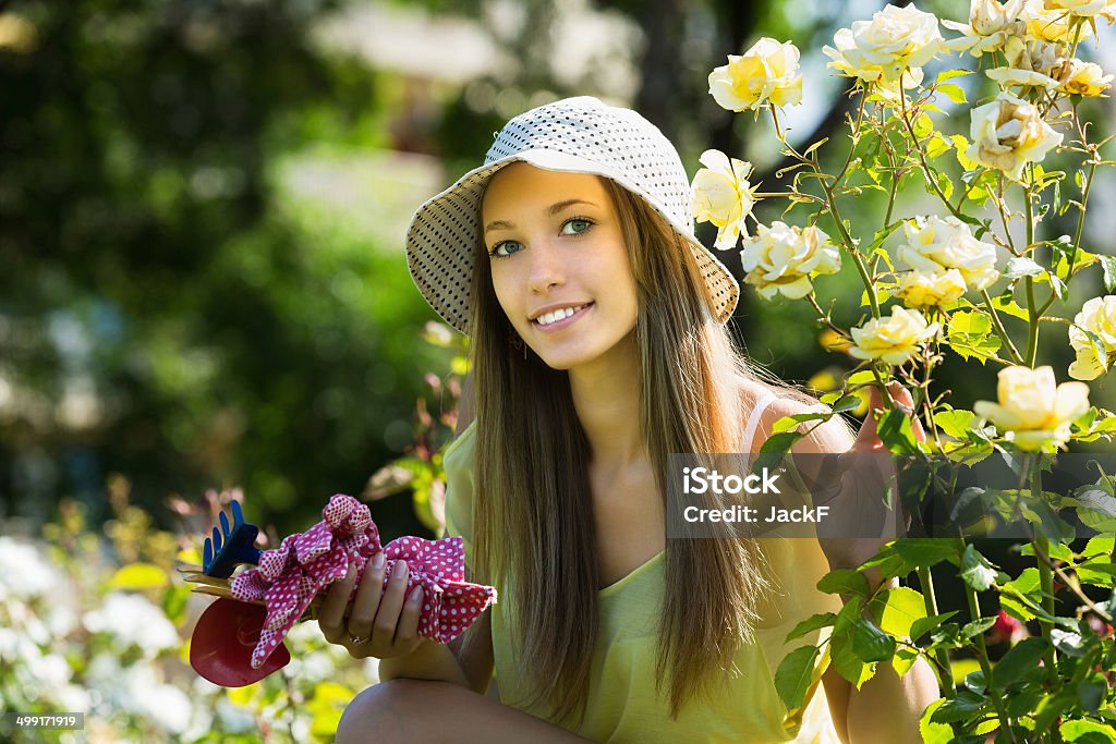 Young florist  in yard gardening Young casual dressed florist in yard gardening with flowers 20-29 Years Stock Photo
