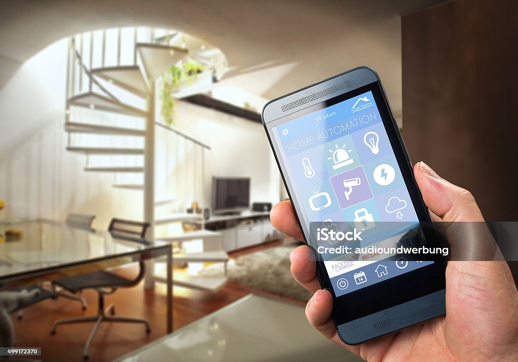 Smart Home Device - Home Control smart house, home automation, device with app icons. Man uses his smartphone with smarthome security app to unlock the door of his house. Home Automation Stock Photo