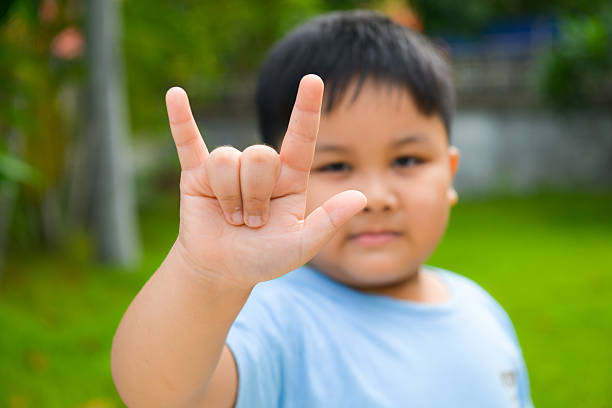 милый мальчик показать любовь символ руки - american sign language сток�овые фото и изображения
