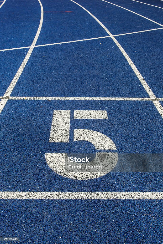Running Track Starting block of a running track around a football field. Blue Stock Photo