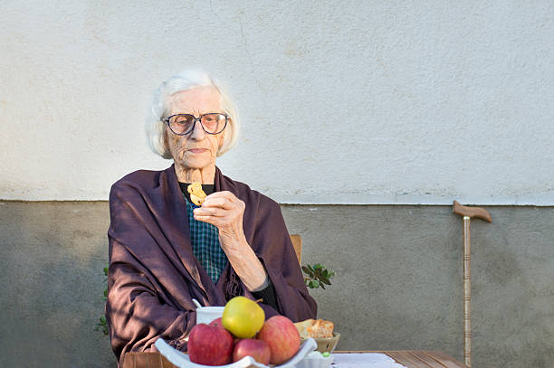 90 years old grandma having a snack in the backyard