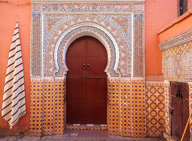 Arabic old style door to a house in an orange wallAncient doors, Morocco