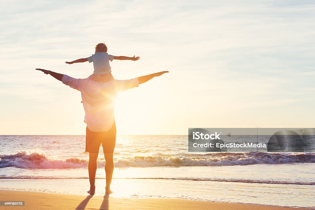 Father and Son Playing Together Happy Father and Son Having Fun Playing on the Beach at Sunset. Fatherhood Family Concept Carefree Stock Photo