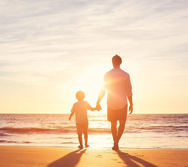 istock Father and Son Walking Together on the Beach 499180234