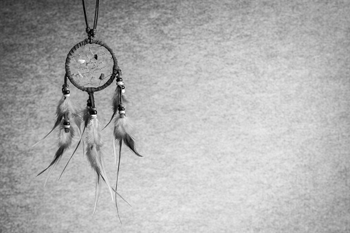 Leather dream catcher on black and white tone background, left copy space