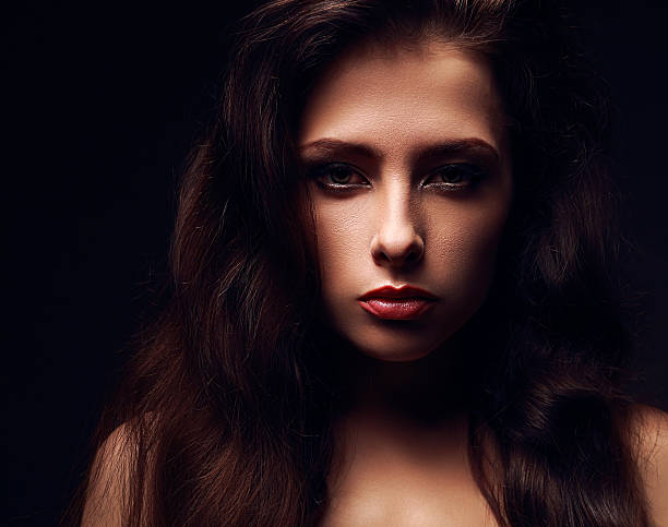 istock Sexy female model face with long hair. Dramatic light. Closeup 499189455