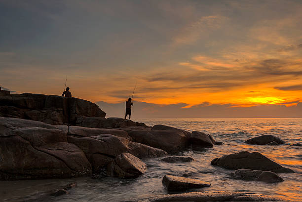 istock fisherman on the rock  silhouette 499190181