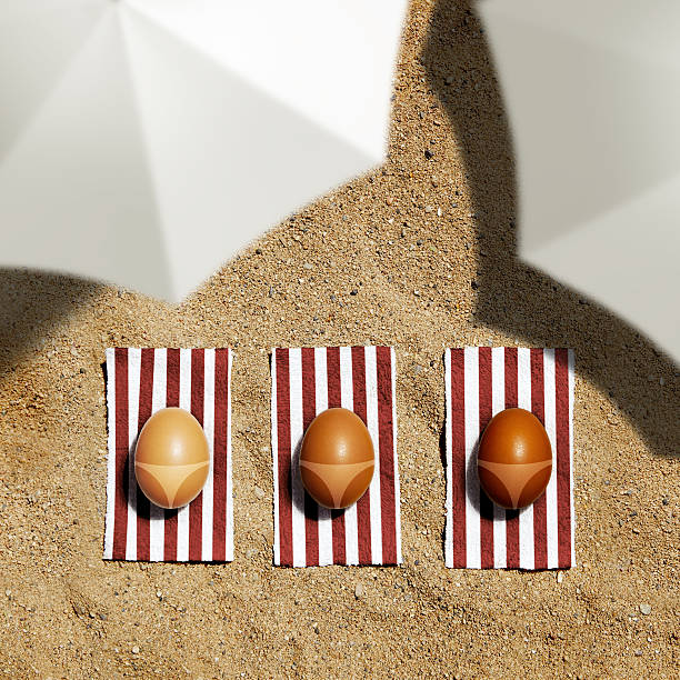 aster eggs under umbrella on a beach stock photo