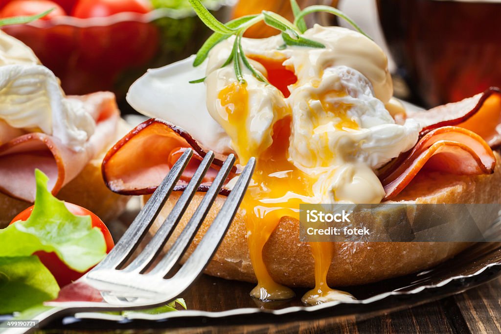 Huevos Benedict en caliente bollos con jamón - Foto de stock de Huevo a la benedictina libre de derechos
