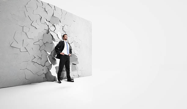 istock businessman breaks trough a wall 499191677