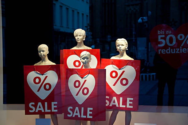 Munich, Germany -- December 26, 2011: Mannequins at the window with red sale and price reduction signs in the windows of a shop day after Christmas