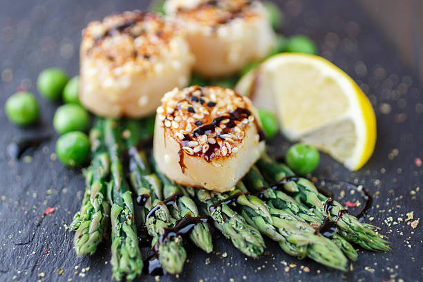 Fried scallop  with sesame seeds, balsamic sauce and asparagus