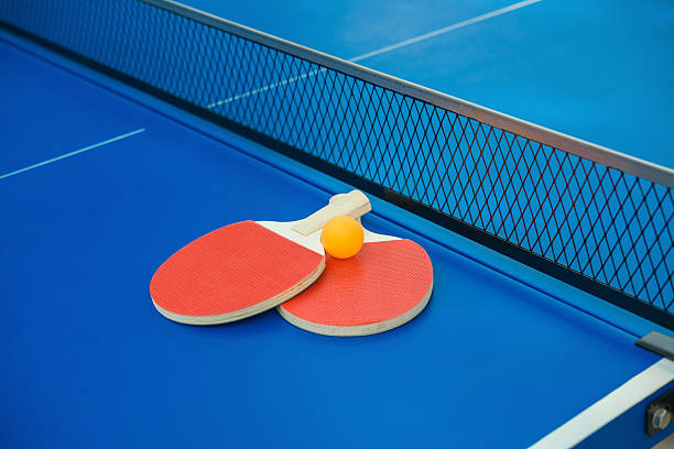 istock pingpong rackets and ball & net on blue pingpong table 499197886