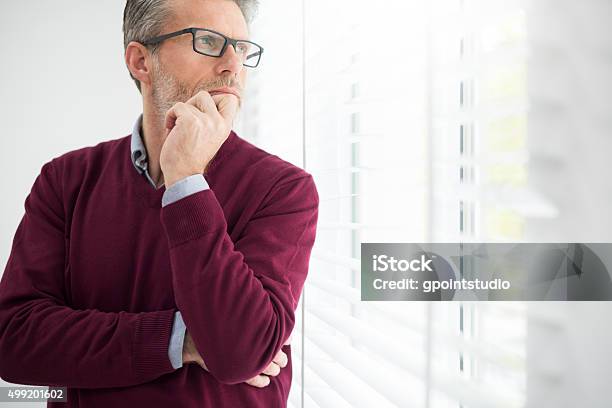 Nachdenklicher Mann Blick Durch Das Fenster Stockfoto und mehr Bilder von Betrachtung - Betrachtung, Männer über 40, Fenster