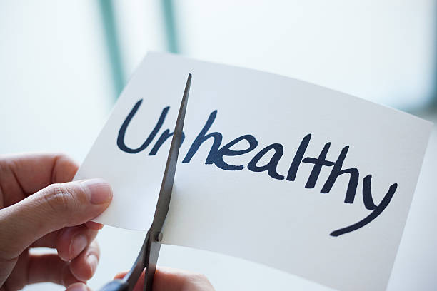 istock Using Scissors Cut the Word on Paper Unhealthy Become Healthy 499201916