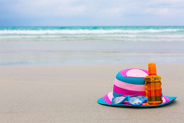 istock Sunscreen lotion and dark glasses with hat on the beach 499204125