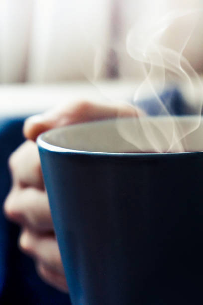 istock Hand holding a cup of tea with white smoke. 499204312