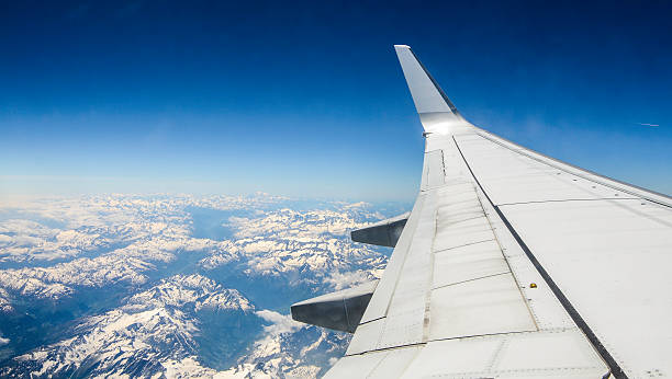 istock airplane wing over snow covered Alps 499205719