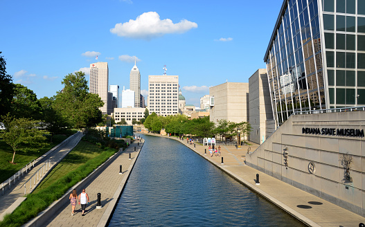 Indianapolis, IN, USA - June 17, 2014: Indianapolis skyline seen from Canal Walk near the Indiana State Museum June 17, 2014. The three mile loop is a popular walking and jogging trail in downtown Indianapolis.