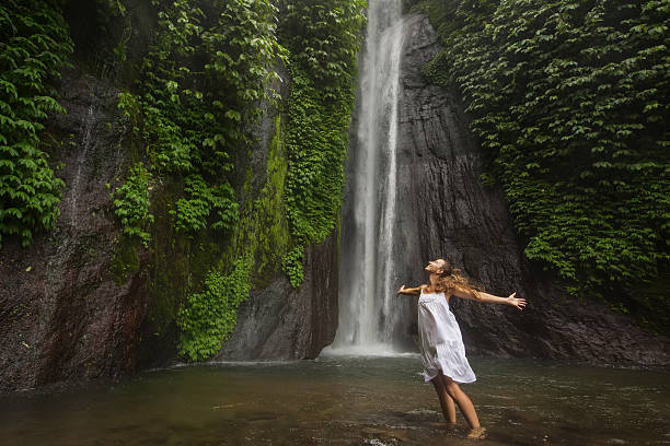 istock woman meditating doing yoga between waterfalls 499207188