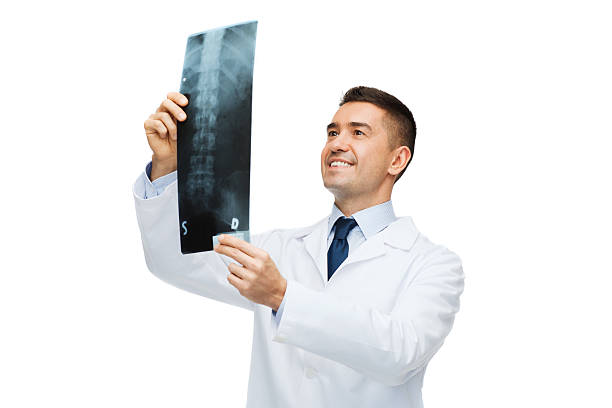 sorridente maschio medico in giacca bianca guardando ai raggi x - scansione scientifica foto e immagini stock