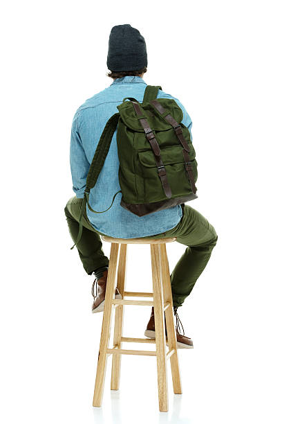 istock Rear view of hipster sitting on stool & looking away 499208153