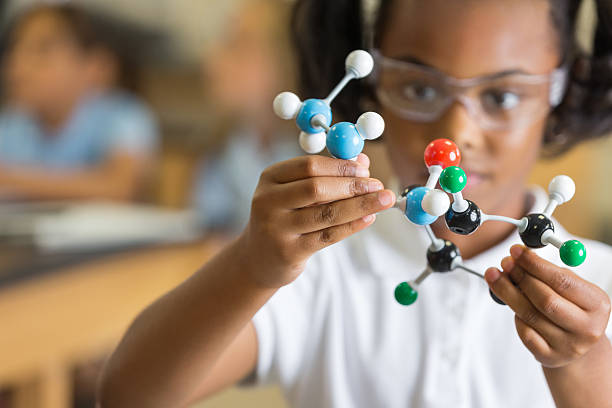 elementary science student mit kunststoff-atom modell lehrreichen spielsachen - chemieunterricht stock-fotos und bilder
