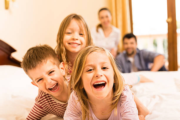 Happy children and their parents in the background.