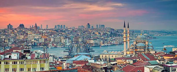 Panoramic image of Istanbul with Yeni Cami Mosque and Galata Bridge during sunset. This is composite of two horizontal images stitched together in photoshop.