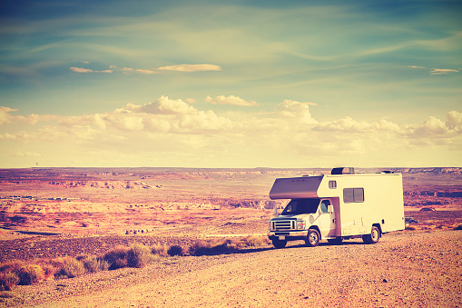 Retro toned camper parked by canyon, family vacation concept, USA.