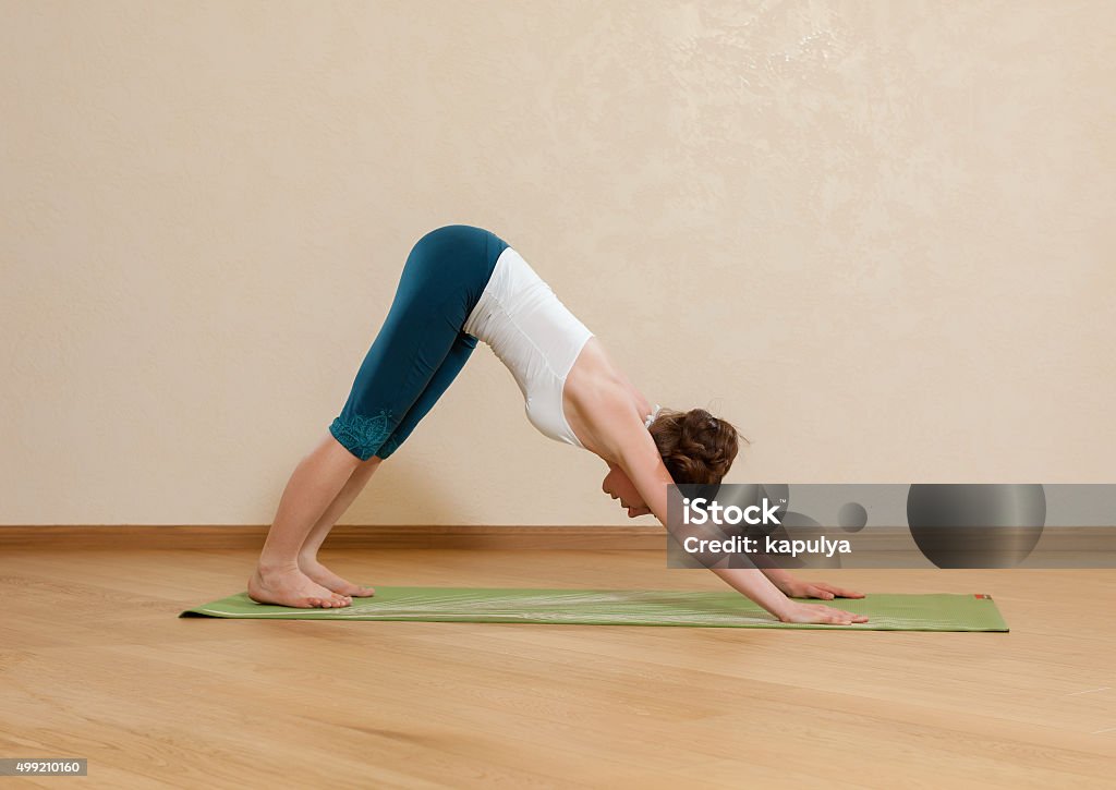 Caucasian woman is practicing yoga at studio (mukha svanasana) 2015 Stock Photo