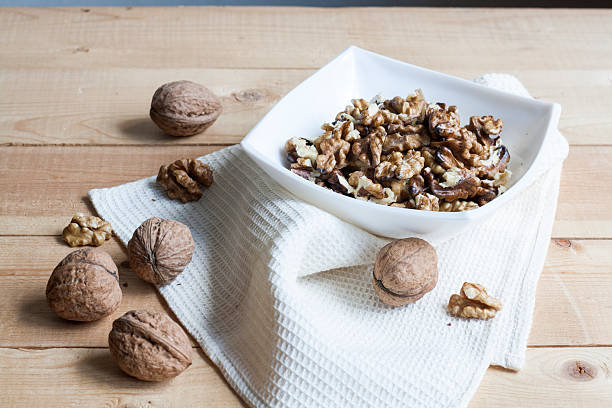 istock Walnuts in a old white bowl on a wooden background 499210594