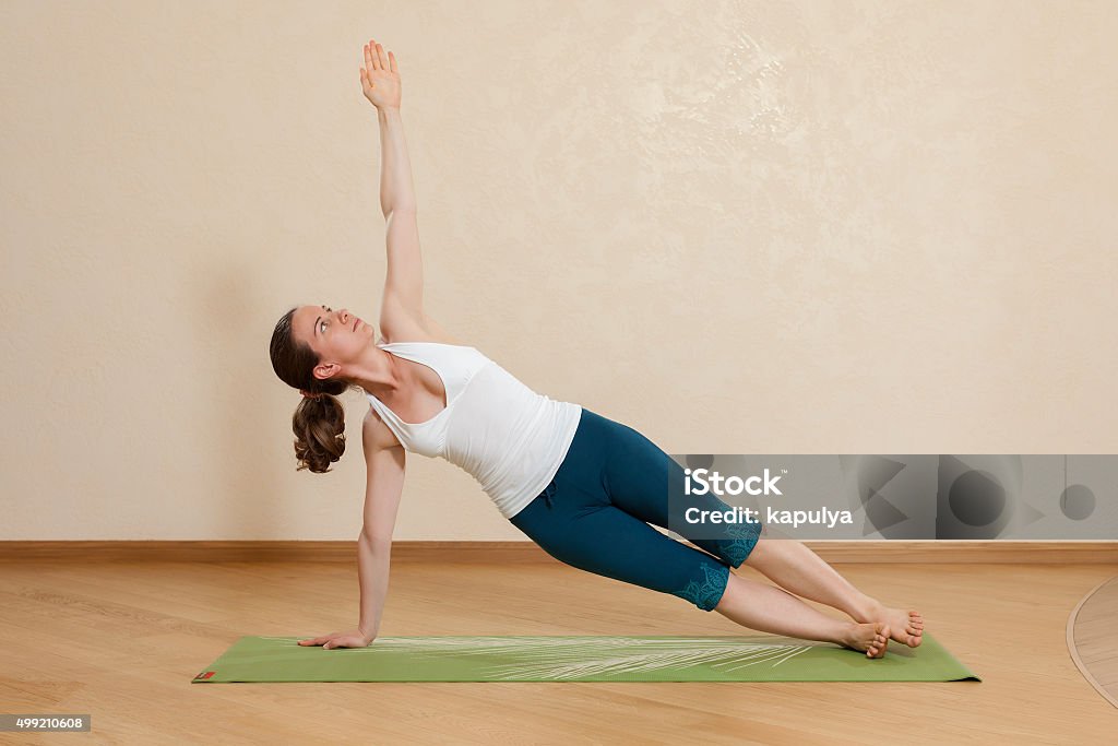 Caucasian woman is practicing yoga at studio (vasishtkhasana) 2015 Stock Photo