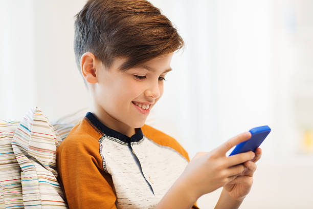 istock boy with smartphone texting or playing at home 499211044