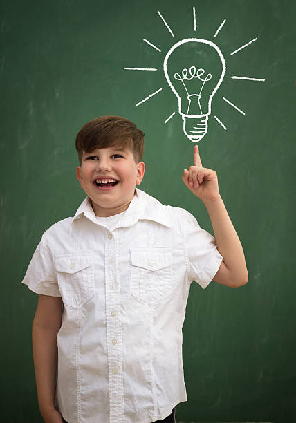 istock happy child against blackboard with drawing light bulb idea 499212076