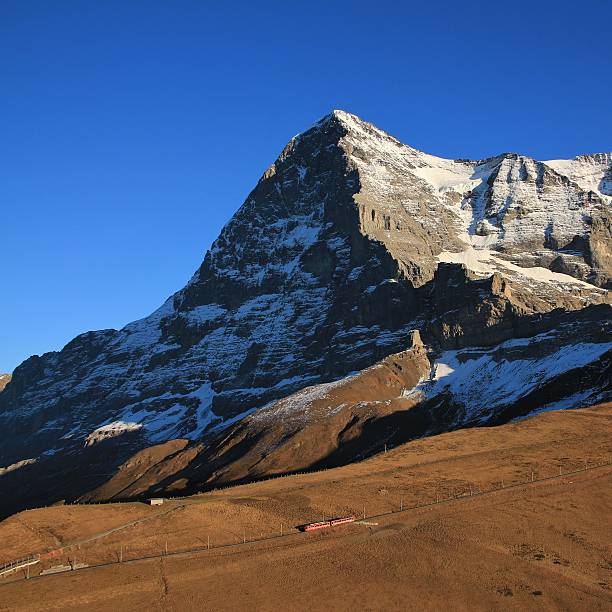 Eiger North Face and train Famous mountain in the Swiss Alps. Train heading towards the Jungfraujoch. eiger northface stock pictures, royalty-free photos & images