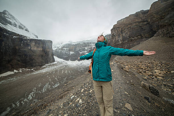 istock Cheering woman arms outstretched on glacier 499226456