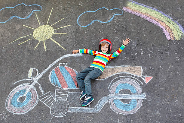 istock Little kid boy in helmet with motorcycle chalks picture 499231302