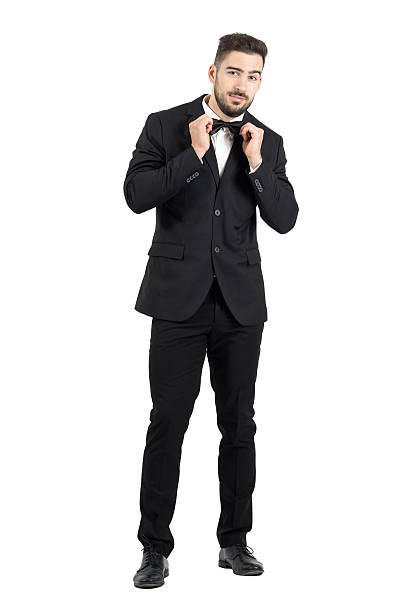 istock Funny young bearded man adjusting bow tie looking at camera 499231878