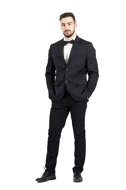 Wealthy confident relaxed young man in tuxedo looking at camera stock photo