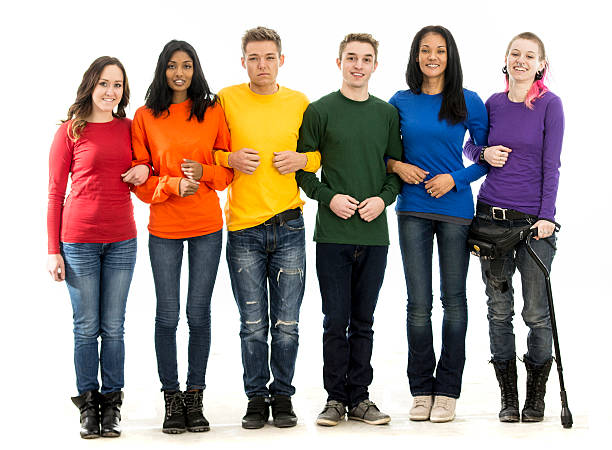 Standing Together for Gay Pride A multi-ethnic group of homosexual young adults are standing together and are wearing the rainbow colors representing the gay community. They are smiling and looking at the camera. arm in arm stock pictures, royalty-free photos & images