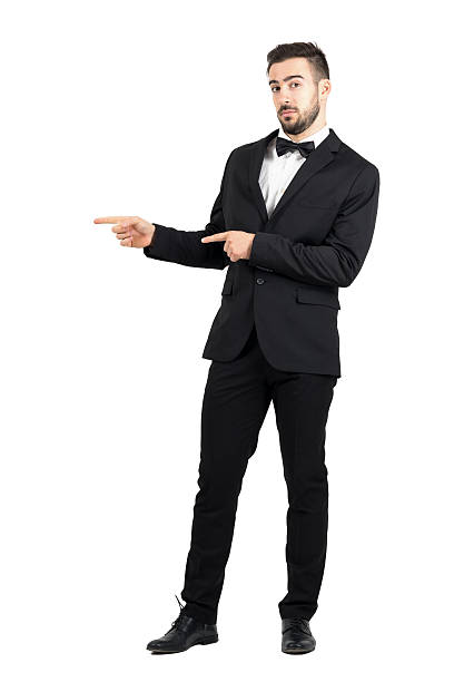 istock Confused luxurious man with bow tie pointing at copyspace 499232344