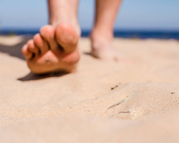 istock man on beach risk of stepping on broken bottle glass 499232440