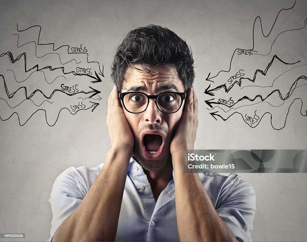 Stress Young man wearing glasses holding his head screaming Covering Stock Photo