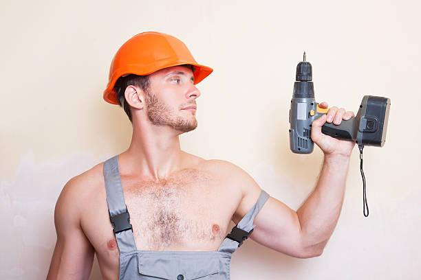 istock Man in overalls with a screwdriver 499233320